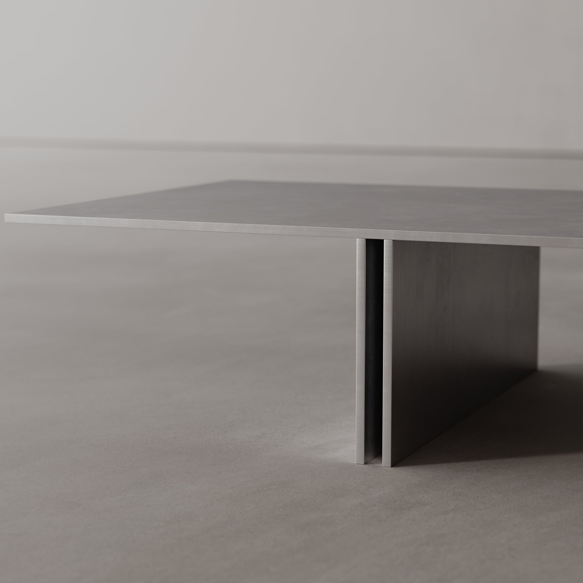 Modern stainless steel table with a minimalist design on a plain background